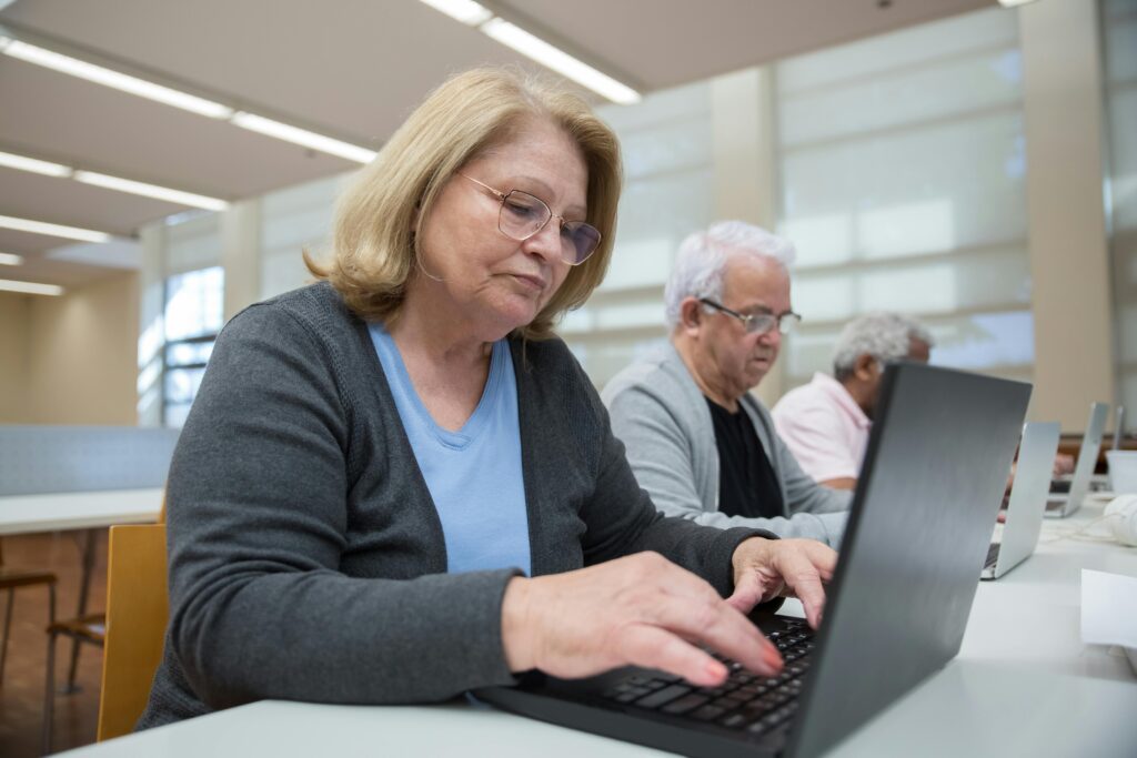 Elderly individuals participating in a computer class to enhance digital skills.